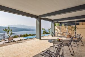 un patio con tavolo, sedie e vista sull'acqua di Heaven's Door Samos a Samos