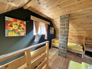 Cette cabane en rondins comprend des lits superposés et une cheminée. dans l'établissement Apartman Kruna, à Kolašin