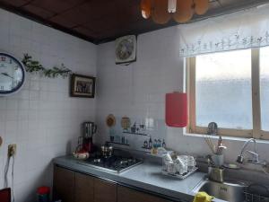 eine Küche mit einem Waschbecken und einer Uhr an der Wand in der Unterkunft Grandmother's Vegetable garden in Anseong