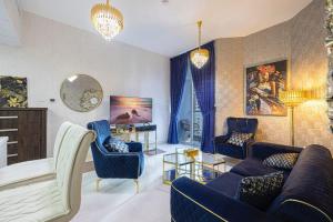 ein Wohnzimmer mit einem blauen Sofa und Stühlen in der Unterkunft Dubai Marina Royal Premium Serviced Apartments Marina Wharf - KIDS STAY FREE in Dubai
