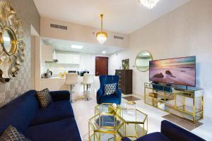 ein Wohnzimmer mit blauen Möbeln und einem großen TV in der Unterkunft Dubai Marina Royal Premium Serviced Apartments Marina Wharf - KIDS STAY FREE in Dubai