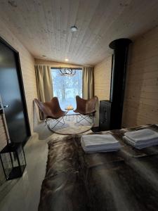 羅瓦涅米的住宿－Skyfire Village Igloos，一间设有两把椅子、一张桌子和一个窗户的房间