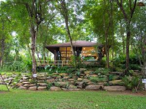 a house in the middle of a forest with trees at Kenaray Farmstay riverside in Kaeng Krachan