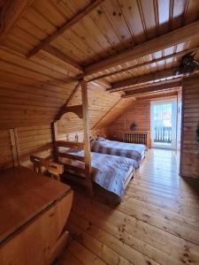 een slaapkamer met een groot bed in een blokhut bij Apartament Rita in Godziszka