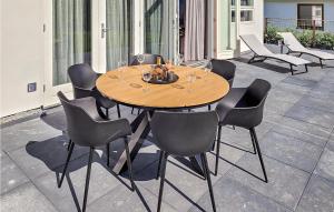 a wooden table and chairs on a patio at Schiermonnikoog in Den Oever