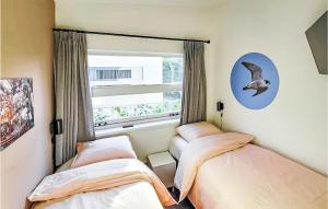 two beds in a room with a window at Schiermonnikoog in Den Oever +5 photos