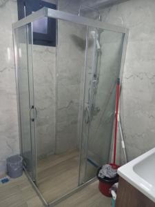 a shower with a glass door in a bathroom at Yaz kış güzel manzaralı ev in Bodrum City