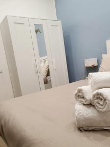 een slaapkamer met een spiegel en handdoeken op een bed bij Colibrì a Piazza Dante in Napels