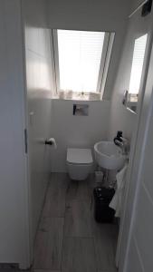 La salle de bains est pourvue d'un lavabo, de toilettes et d'une fenêtre. dans l'établissement Domek Zakopiański Widok, à Zakopane