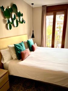 a bedroom with a large white bed with colorful pillows at Hostal La Canonja in Tremp