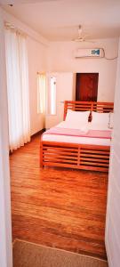 um quarto com uma cama grande e piso em madeira em Marari Sailor Homes em Shertallai