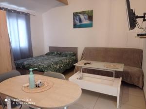 a small living room with a couch and a table at Maisonnette A Santa Ghjulia entre Mer & Montagne in Volpajola