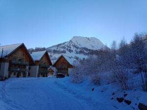 eine schneebedeckte Straße vor einer Lodge in der Unterkunft Appartement 6/8 pers à 200 m des pistes - piscine in Saint-Sorlin-dʼArves