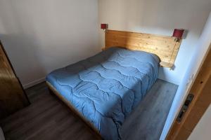 małą sypialnię z niebieskim łóżkiem w pokoju w obiekcie Appartement 6/8 pers à 200 m des pistes - piscine w mieście Saint-Sorlin-dʼArves +23 zdjęcia