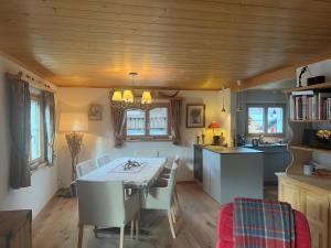 una cucina e una sala da pranzo con tavolo e sedie di Gäuggeliweg 36, Klosters a Klosters