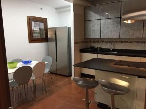 a kitchen with a table and chairs and a refrigerator at Fantástica casa con piscina privada in Níjar