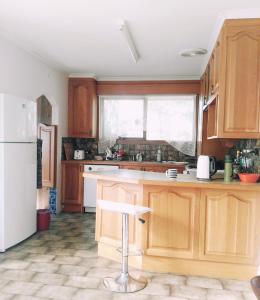 a kitchen with wooden cabinets and a white refrigerator at 带浴室和步入式衣柜的舒适主卧Master bedroom with Shower room in Forest Hill