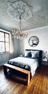 een slaapkamer met een bed en een kroonluchter bij Belle Époque in Solingen