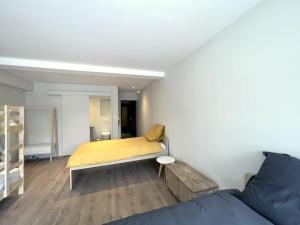 um quarto com uma cama com um cobertor amarelo em Maison 15 personnes périphérie de Clermont-Ferrand em Romagnat