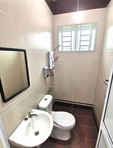 a bathroom with a toilet and a sink and a mirror at Batu Pahat Karaoke LawnView TvBox BBQ Villa in Batu Pahat +42 photos