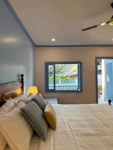 a bedroom with a large bed and a window at Sadakham Hotel in Luang Prabang