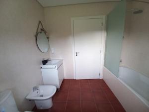 a bathroom with a toilet and a sink and a mirror at Casa da Dina in Ponte de Lima