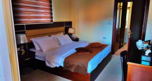 1 dormitorio con 1 cama grande con almohadas blancas en Shaqilath Hotel en Wadi Musa