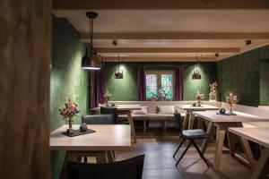 ein Restaurant mit grünen Wänden, Tischen und Stühlen in der Unterkunft Breitachhus in Riezlern