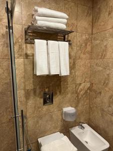 y baño con aseo, lavabo y toallas. en Shaqilath Hotel en Wadi Musa
