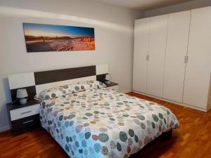 a bedroom with a bed and a painting on the wall at Apartamento Jarauta 50 in Pamplona
