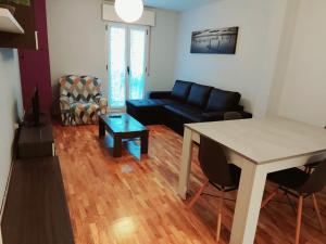 a living room with a black couch and a table at Apartamento Jarauta 50 in Pamplona