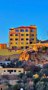 un edificio amarillo en la cima de una montaña en Shaqilath Hotel, en Wadi Musa