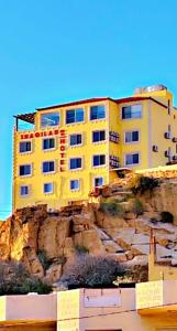 a yellow building on the side of a mountain at Shaqilath Hotel in Wadi Musa