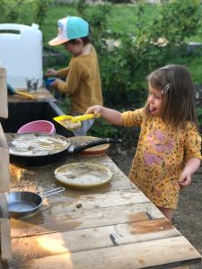 Una bambina in piedi accanto a un tavolo che prepara il cibo di Chalupa U Kubů a Plavy