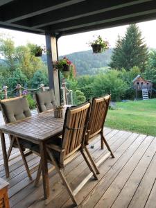 un tavolo e sedie in legno su una terrazza di legno di Chalupa U Kubů a Plavy