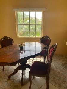 a dining room table with chairs and a window at Cummin up in Fort Jeudy