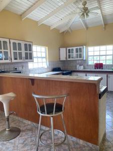 a large kitchen with a bar with a chair in it at Cummin up in Fort Jeudy