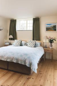 a bedroom with a large bed with two pillows at Trevigue Farm in Crackington Haven