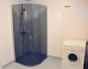 ducha con puerta de cristal junto a una lavadora en ANNA Jeppo Guesthouses, en Uusikaarlepyy 20 fotos más