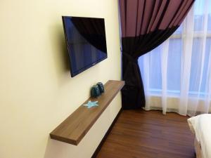 a room with a tv on a wall with a window at 9 Square Hotel - Bangi in Bangi