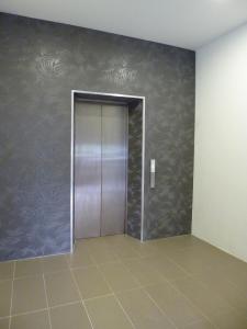 an elevator door in a room with a tile floor at 9 Square Hotel - Bangi in Bangi