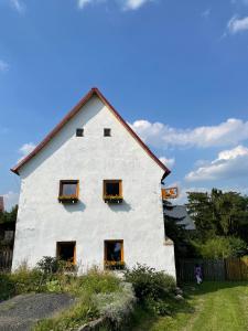 Bílka 33 - Village home in the Czech Central Highlands في Bořislav: بيت ابيض وفيه نافذتين وسياج