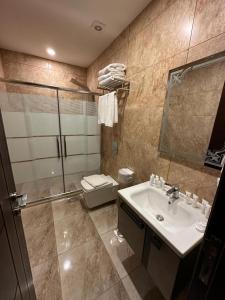 y baño con lavabo, ducha y aseo. en Shaqilath Hotel, en Wadi Musa
