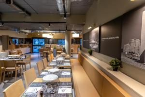 uma longa sala de jantar com mesas e cadeiras em Birgit Hôtel Le Havre Centre em Le Havre