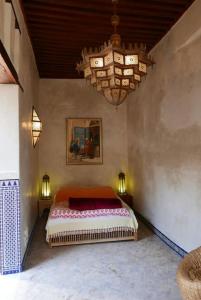 - une chambre avec un lit et un lustre dans l'établissement House in the old Medina of Fez, à Fès al Bali