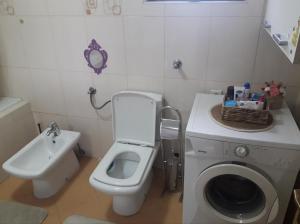 y baño con aseo, lavabo y lavadora. en Kuća za odmor La Mia Casa, en Doboj