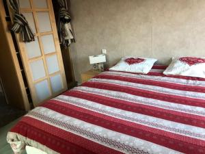 a bed with a red and white striped blanket at villa Padivier in Saint-Point-Lac