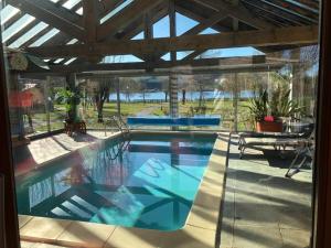 una piscina en una casa con techo de madera en villa Padivier en Saint-Point-Lac