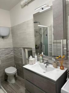 ein Badezimmer mit einem Waschbecken, einem WC und einem Spiegel in der Unterkunft Il Sogno in Spello