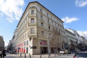 wysoki budynek przy ulicy miejskiej z samochodami w obiekcie Budapest Eye Apartment w Budapeszcie